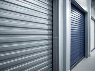 Close-up view of steel and colored roll up garage doors in a modern residential setting