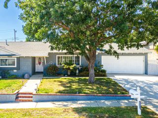 Front view of a suburban home with a new garage door and fenced yard in Anaheim.