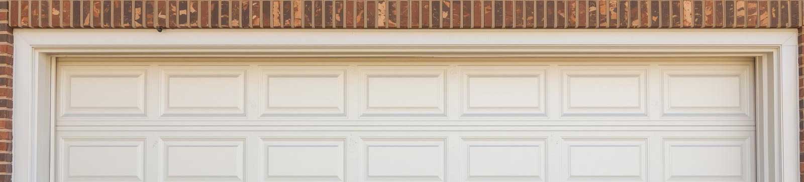 Closed white-paneled overhead garage door installed in a brick Anaheim home, symbolizing professional repair and service
