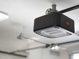 Close-up of modern garage door opener installed on ceiling rail, highlighting automated technology and maintenance needs