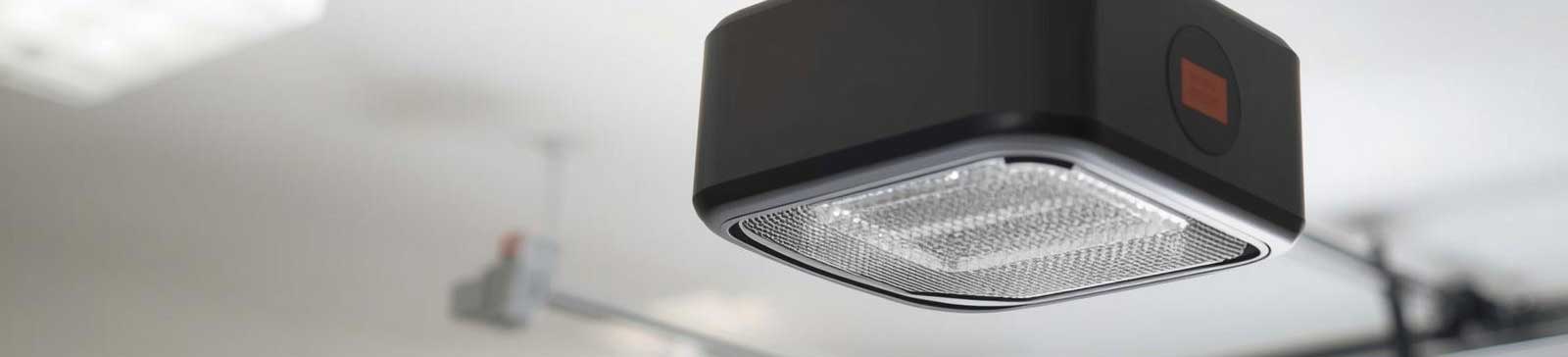 Close-up of modern garage door opener installed on ceiling rail, highlighting automated technology and maintenance needs